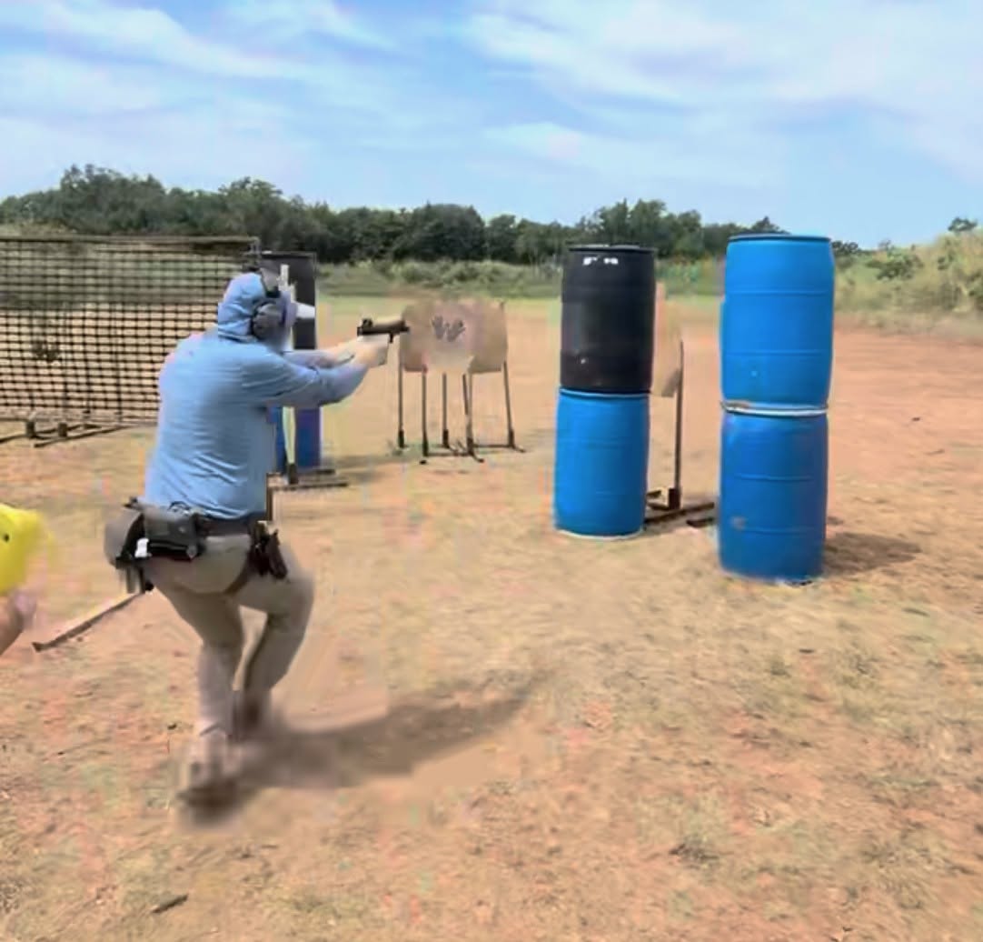 A competitor shooting a stage at a Galactic Pistol Alliance pistol match at the SRPC range, moving between barrel props toward paper targets.